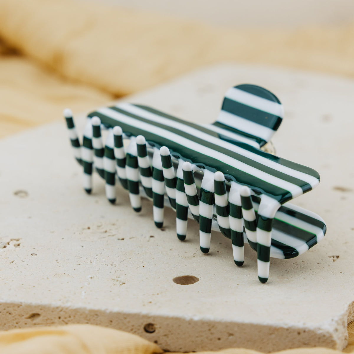 Pince à cheveux Lucette vue de profil, dents rayées vert et blanc